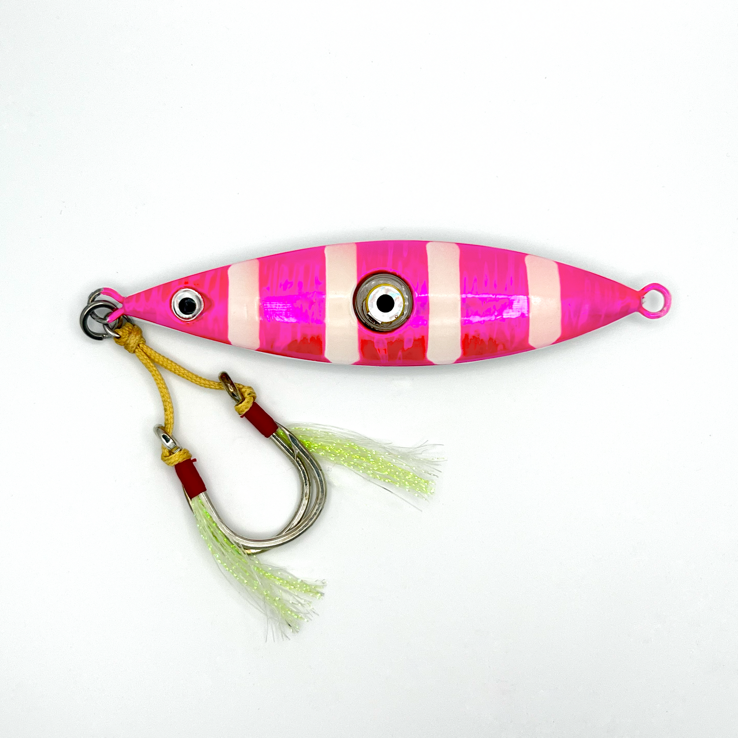Pink Jig fishing lure. Reflective pink lure with four horizontal white stripes, two hooks with skirts, and light-up eye in center.