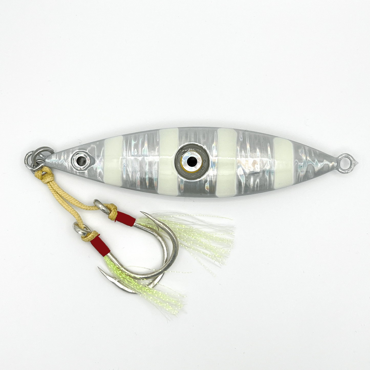 Silver Jig fishing lure. Reflective silver lure with four horizontal white stripes, two hooks with skirts, and light-up eye in center.